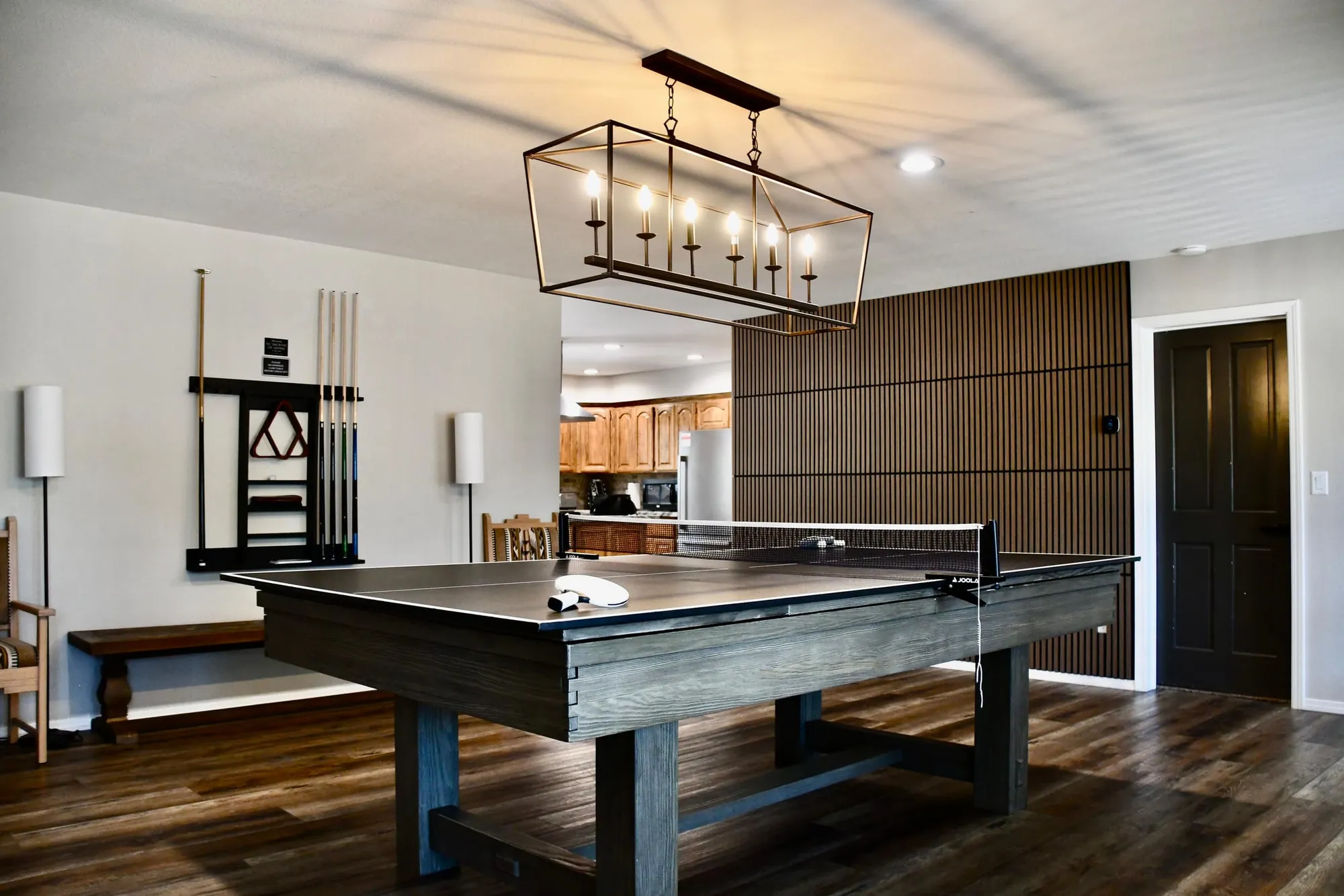 The game room with a ping-pong table, cue rack and a lantern chandelier