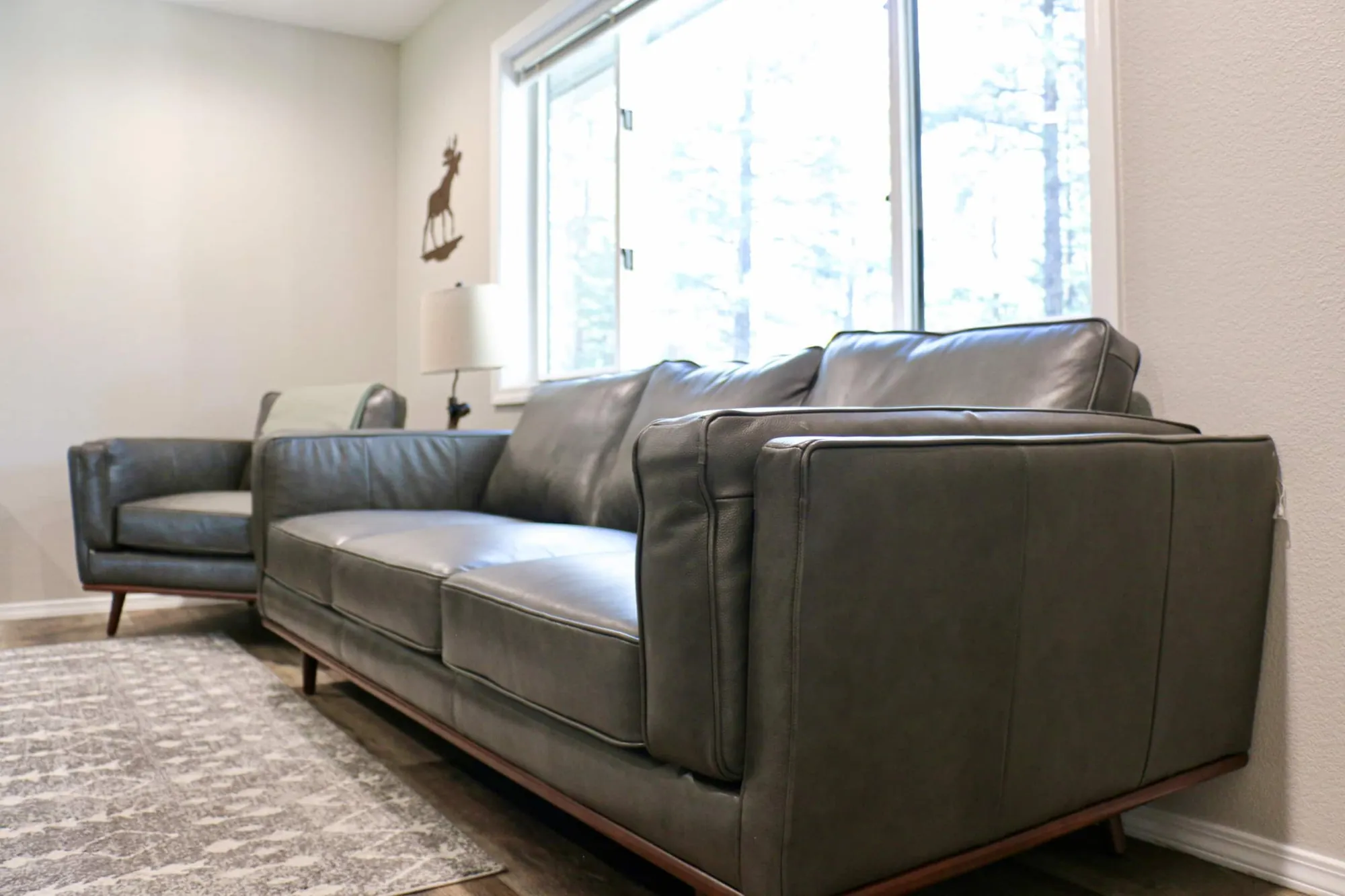 Living room with leather sofas, a slatted wood wall and a large TV